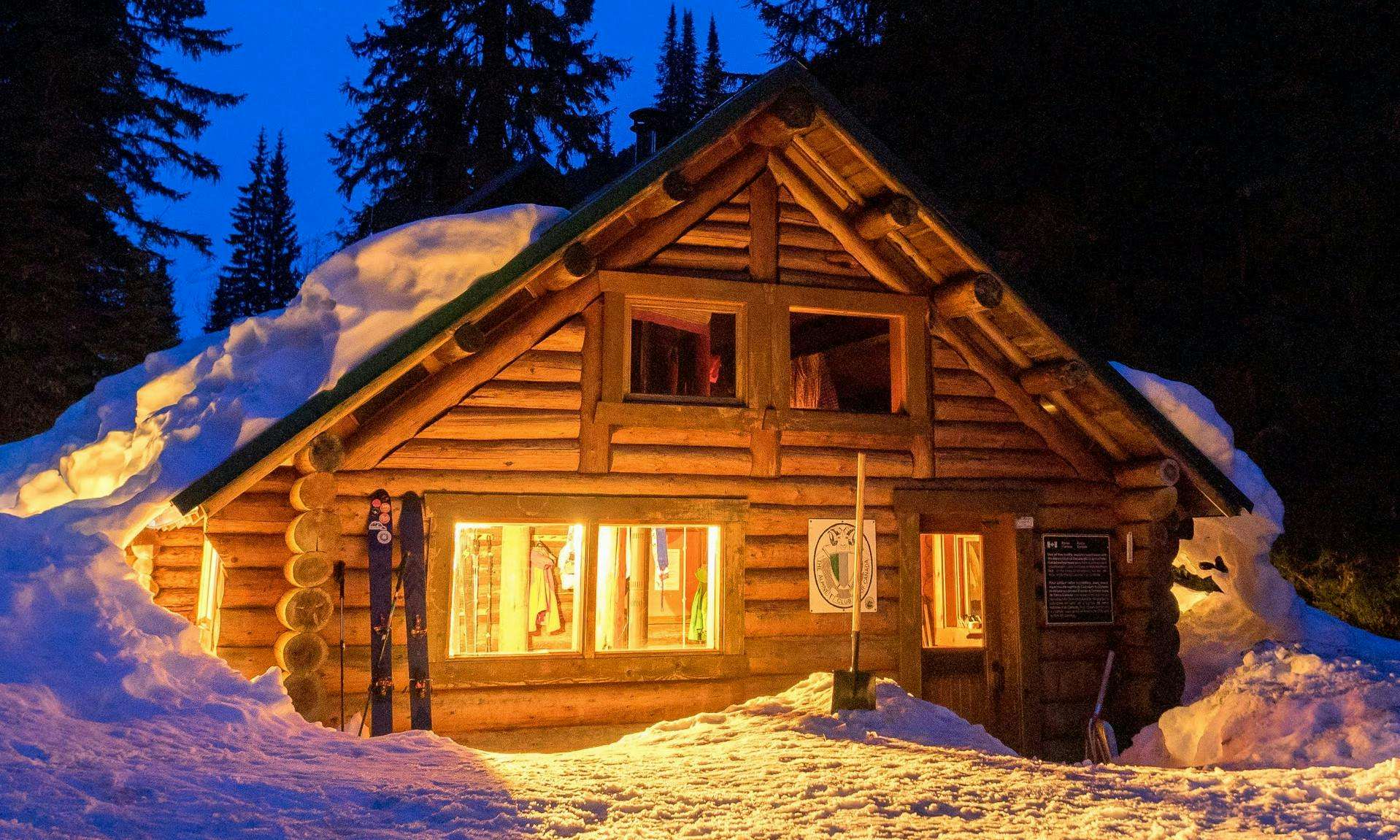Wood cabin in a winter forest at night