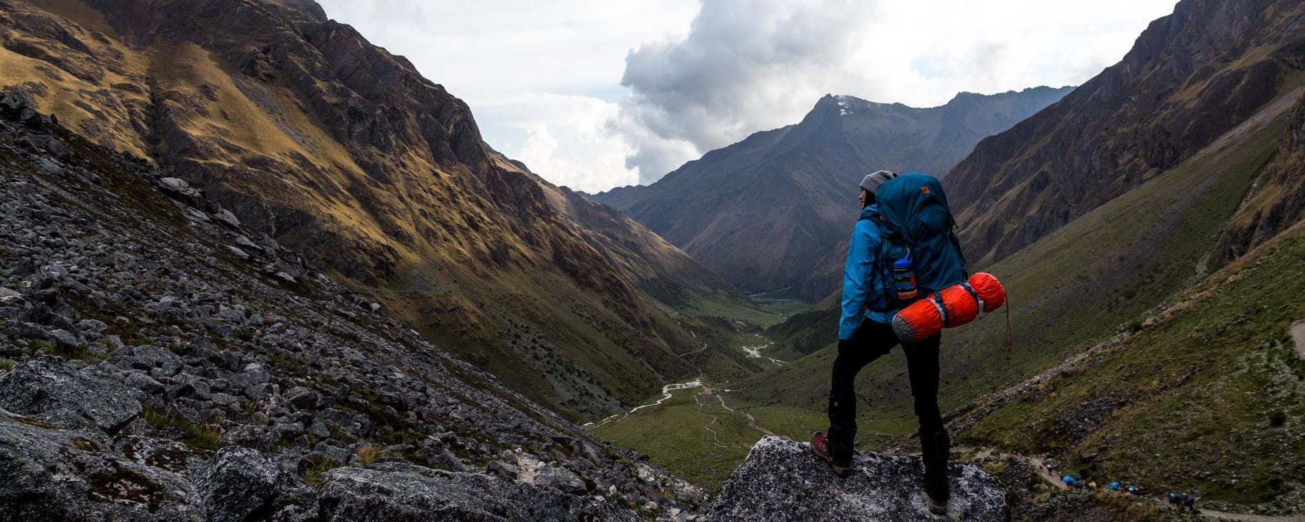 Kieren Britton hiking with a backpack and tent in a mountain valley