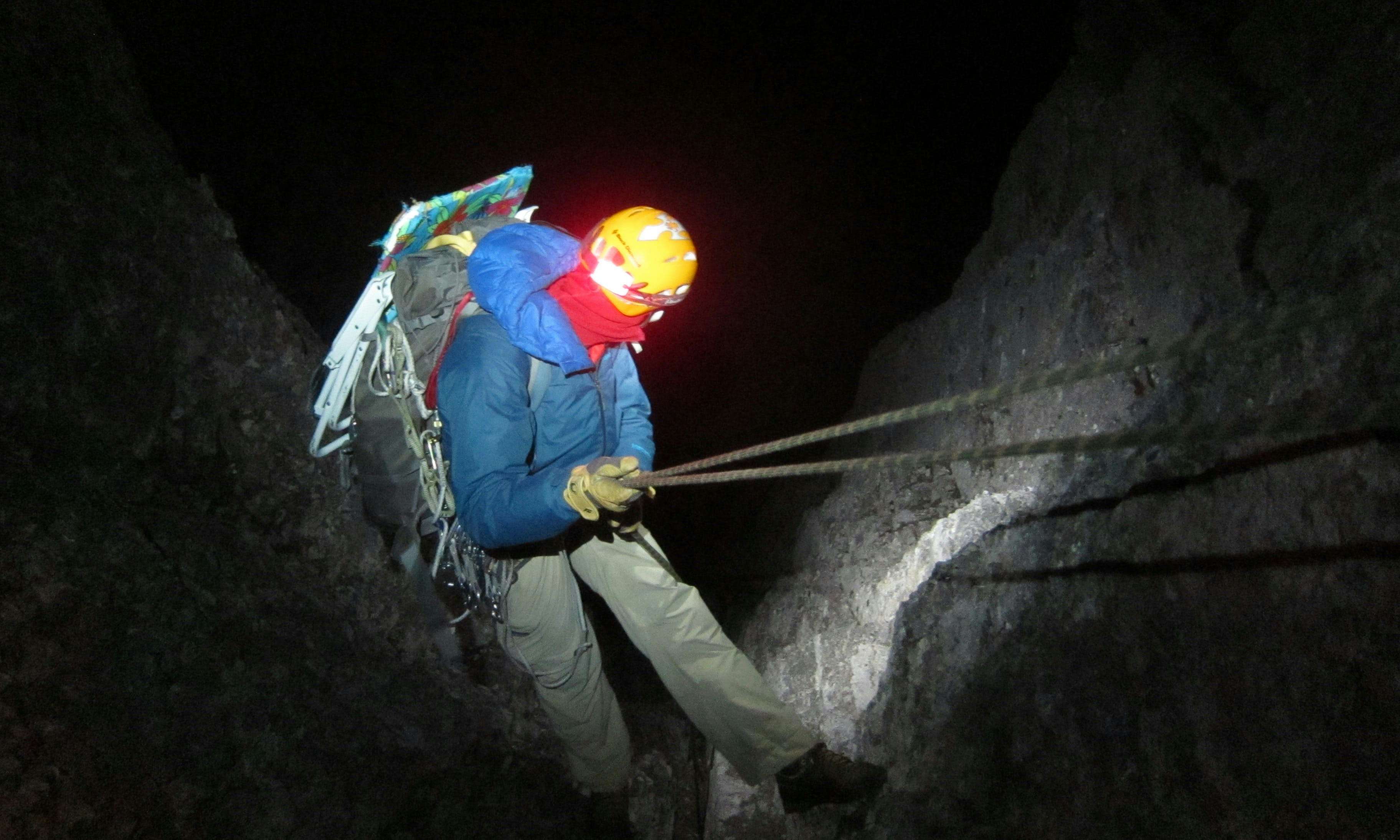 Climber going down a Mount Louis at night