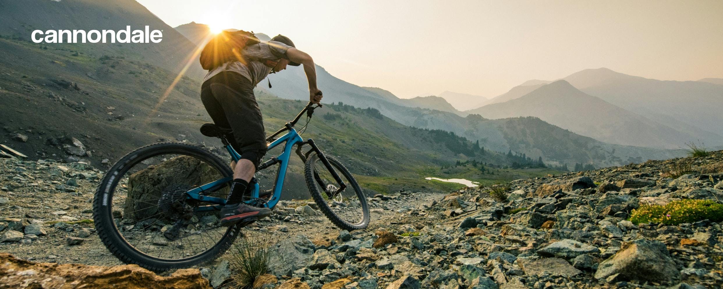 Person riding a Cannondale mountain bike in the mountains near dusk