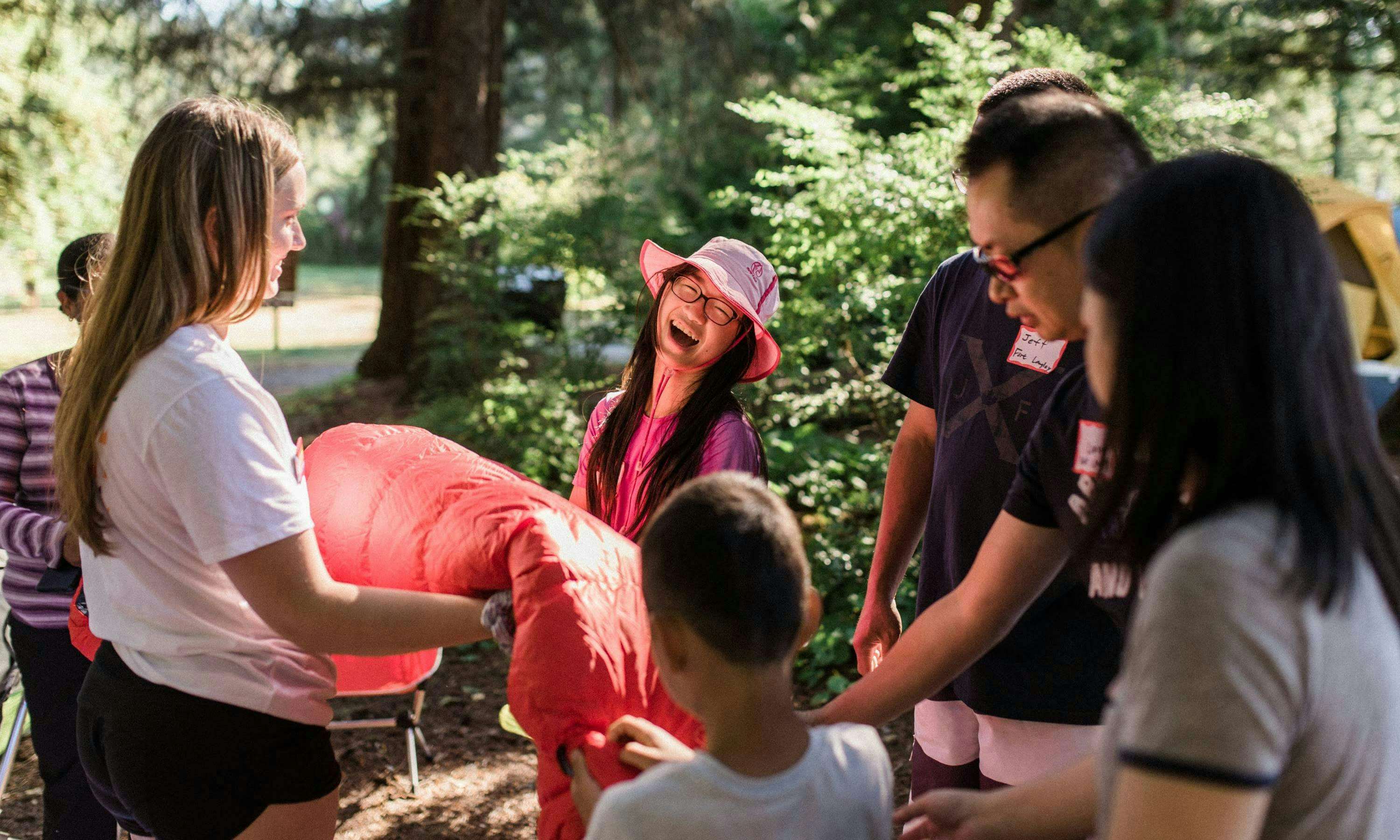 Campers learning about a red sleeping bag at a learn-to-camp event