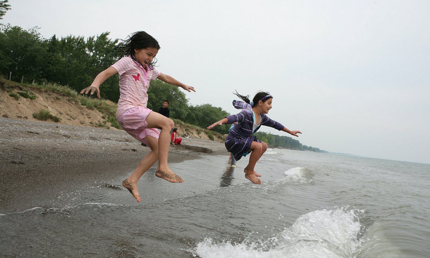 Kids jumping in the water at Wheatley Provincial Park, Ontario