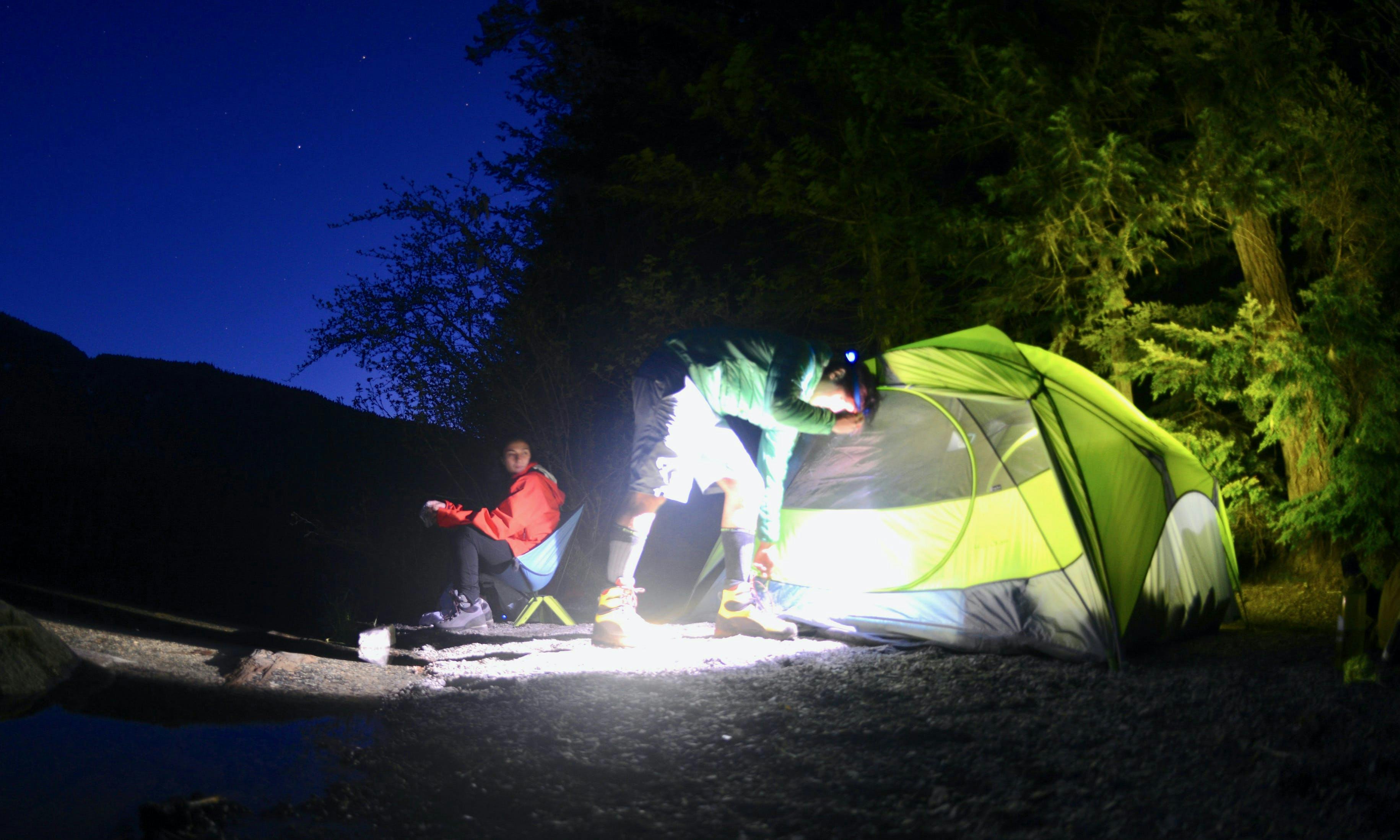 Campers setting up a tent in the dark