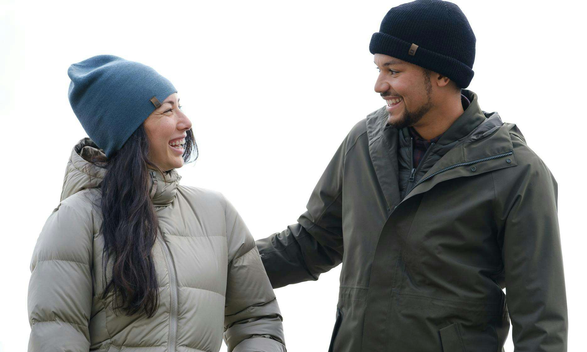 Two people laughing in toques