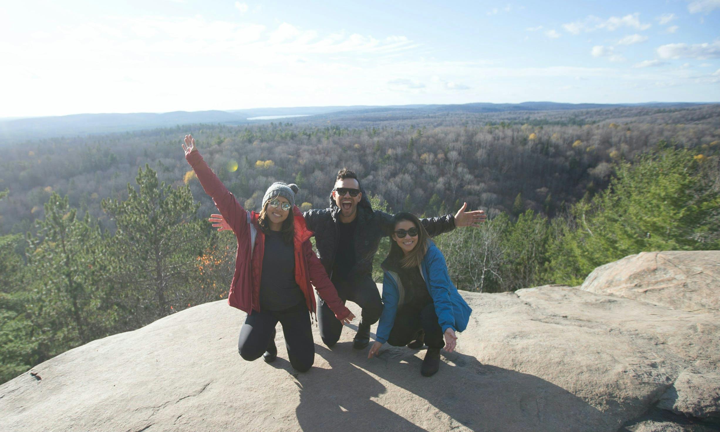 Three hikers posing for a photo on a rock
