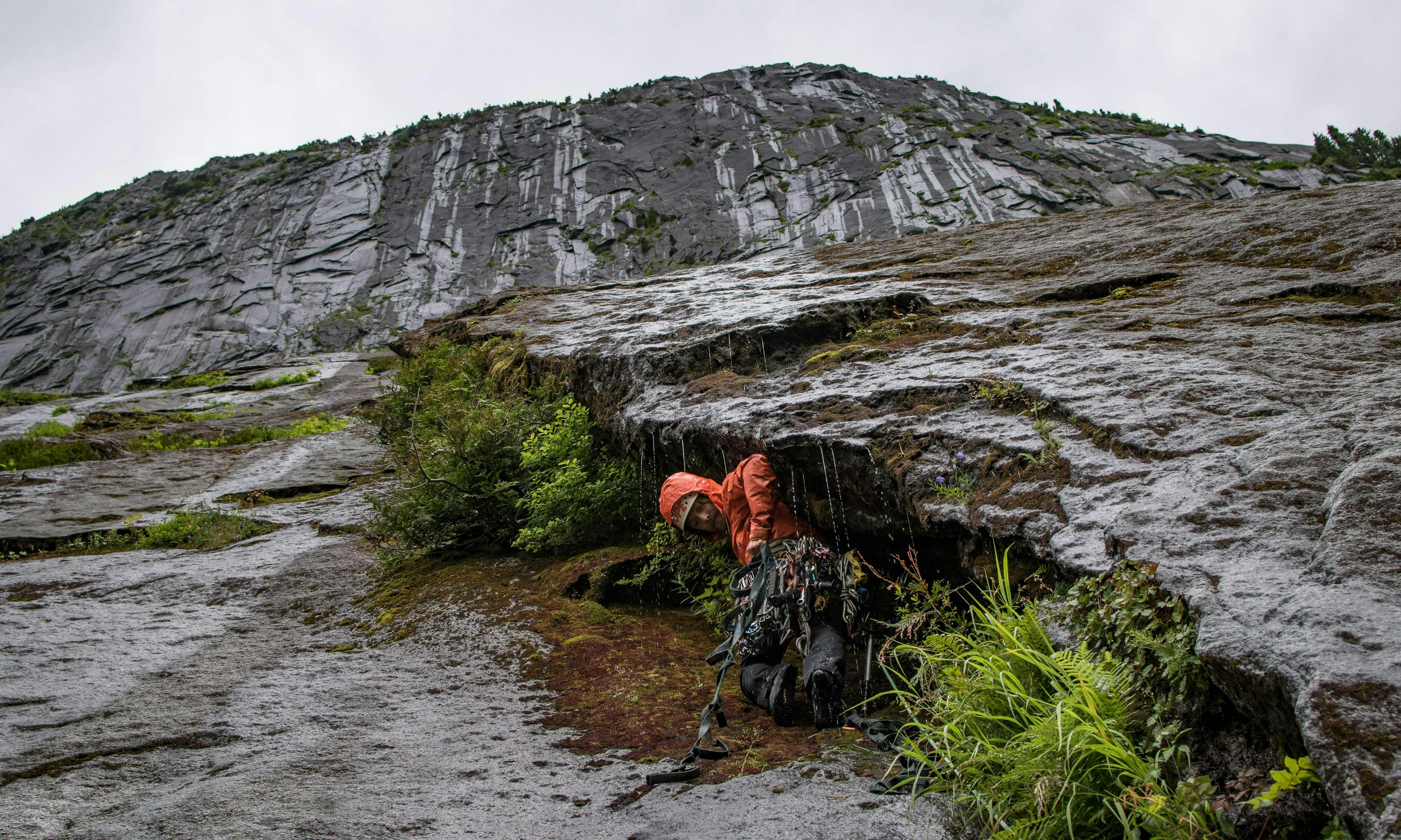 Climber leading route in a full deluge of rain