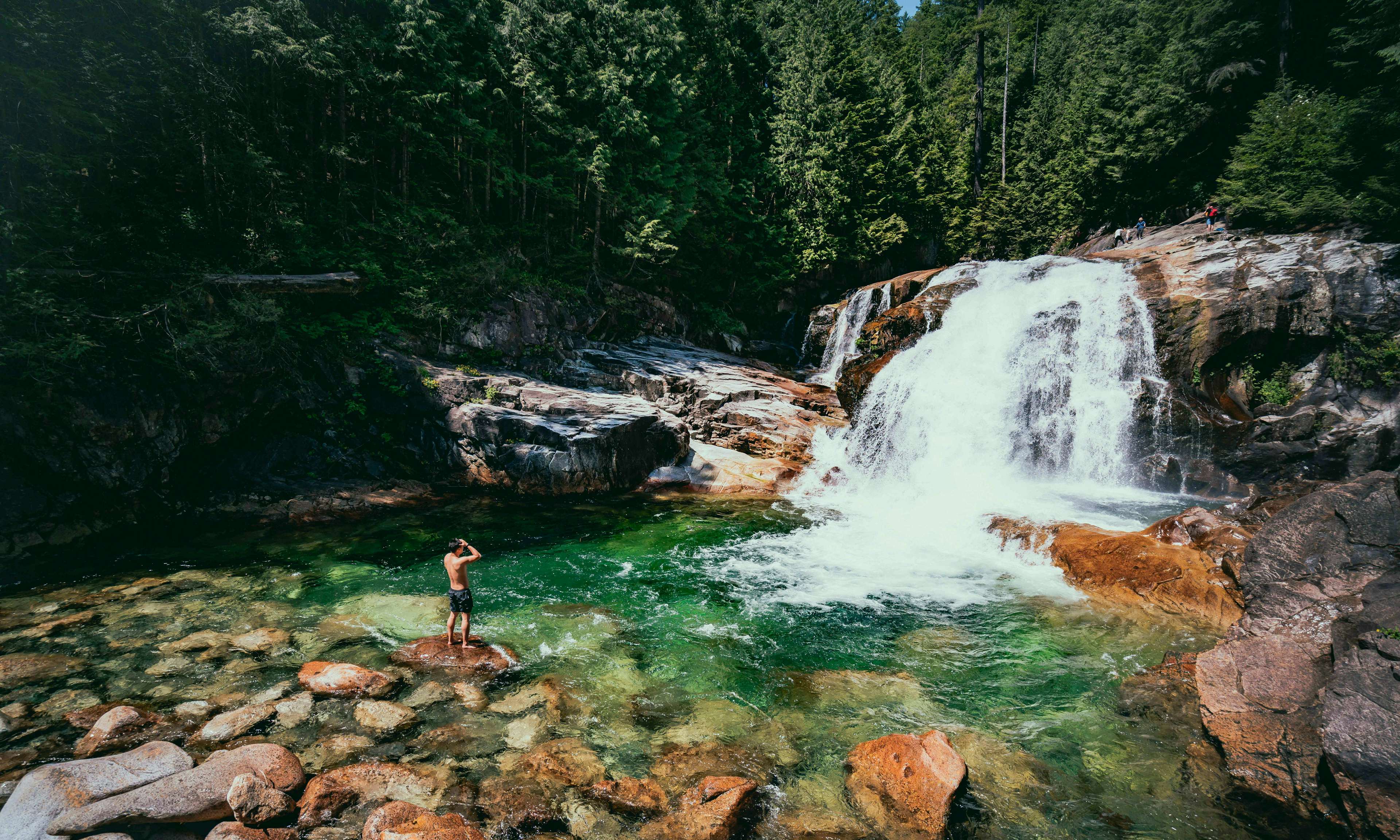 Person standing near waterfall in Golden Ears Provincial Park