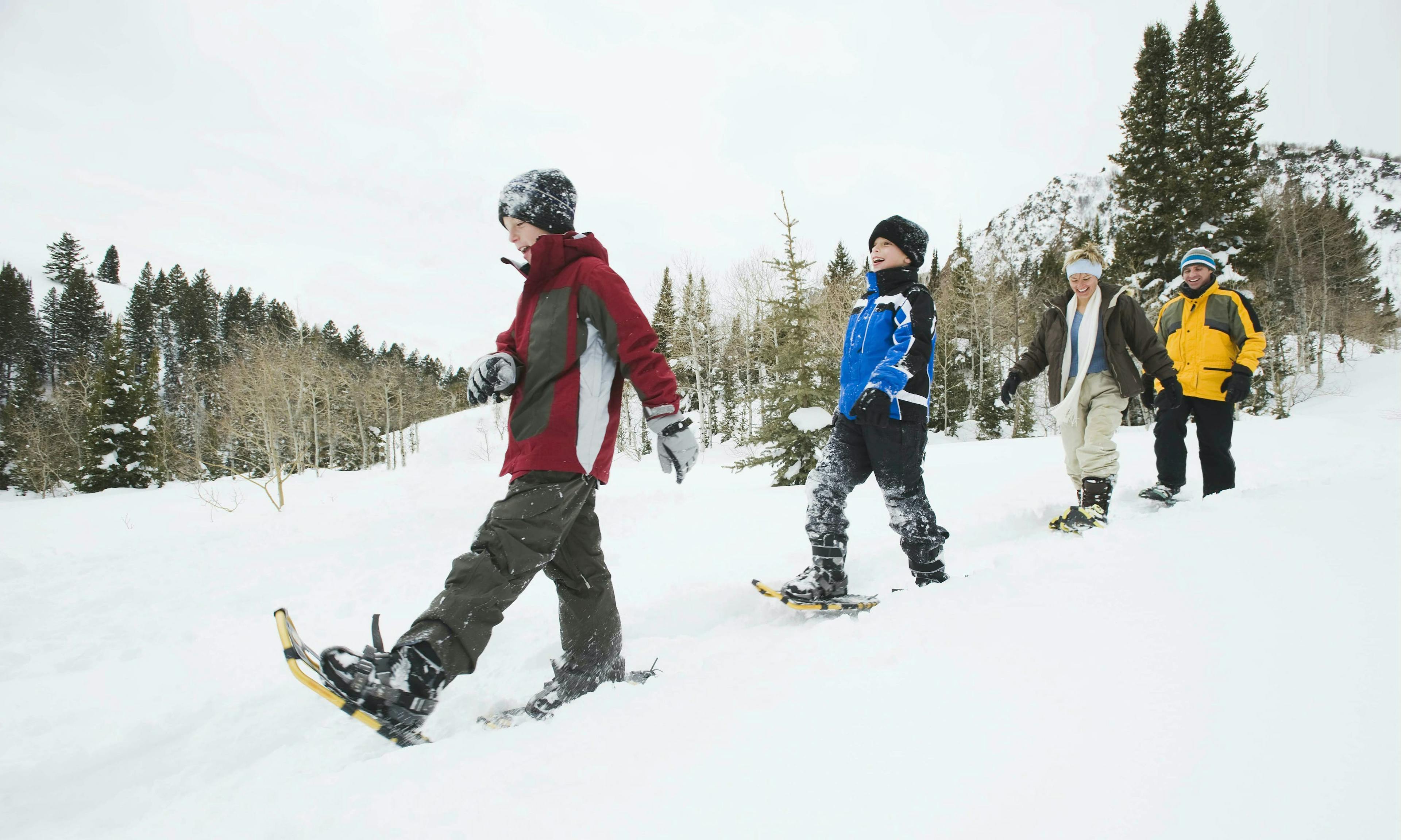 Young boys snowshoeing with parents
