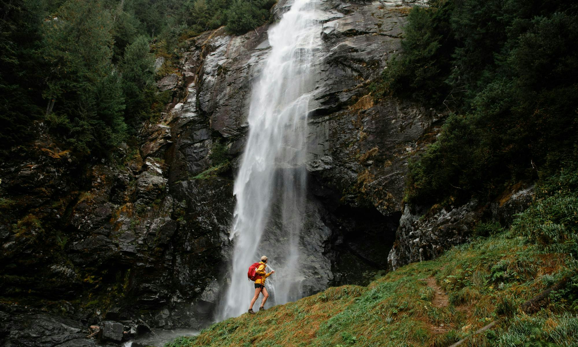 Person standing in front of large waterfalls