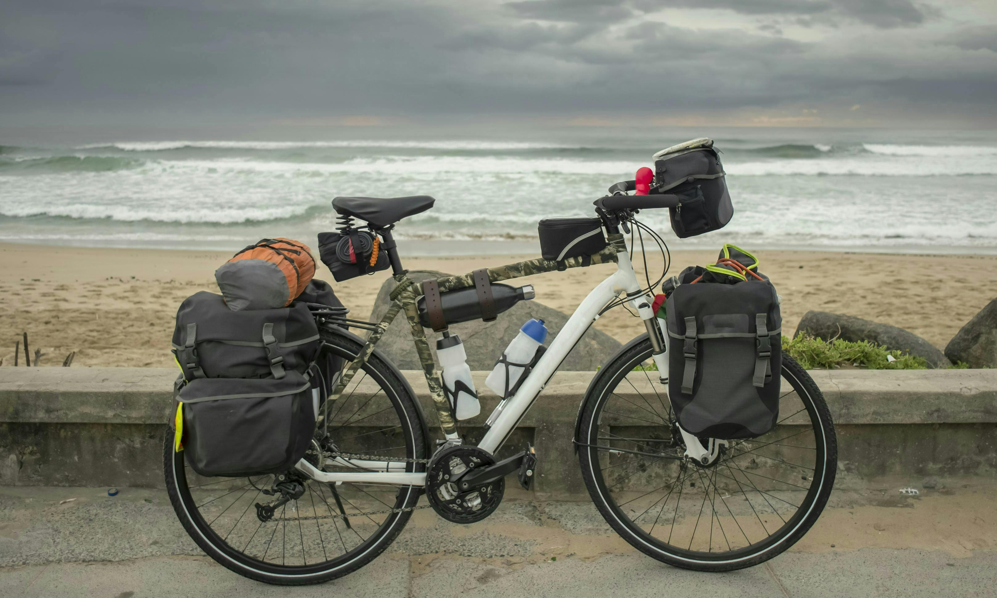 Fully kitted out for bike touring, with front and back panniers, a handlebar frame bag and a small seat bag.