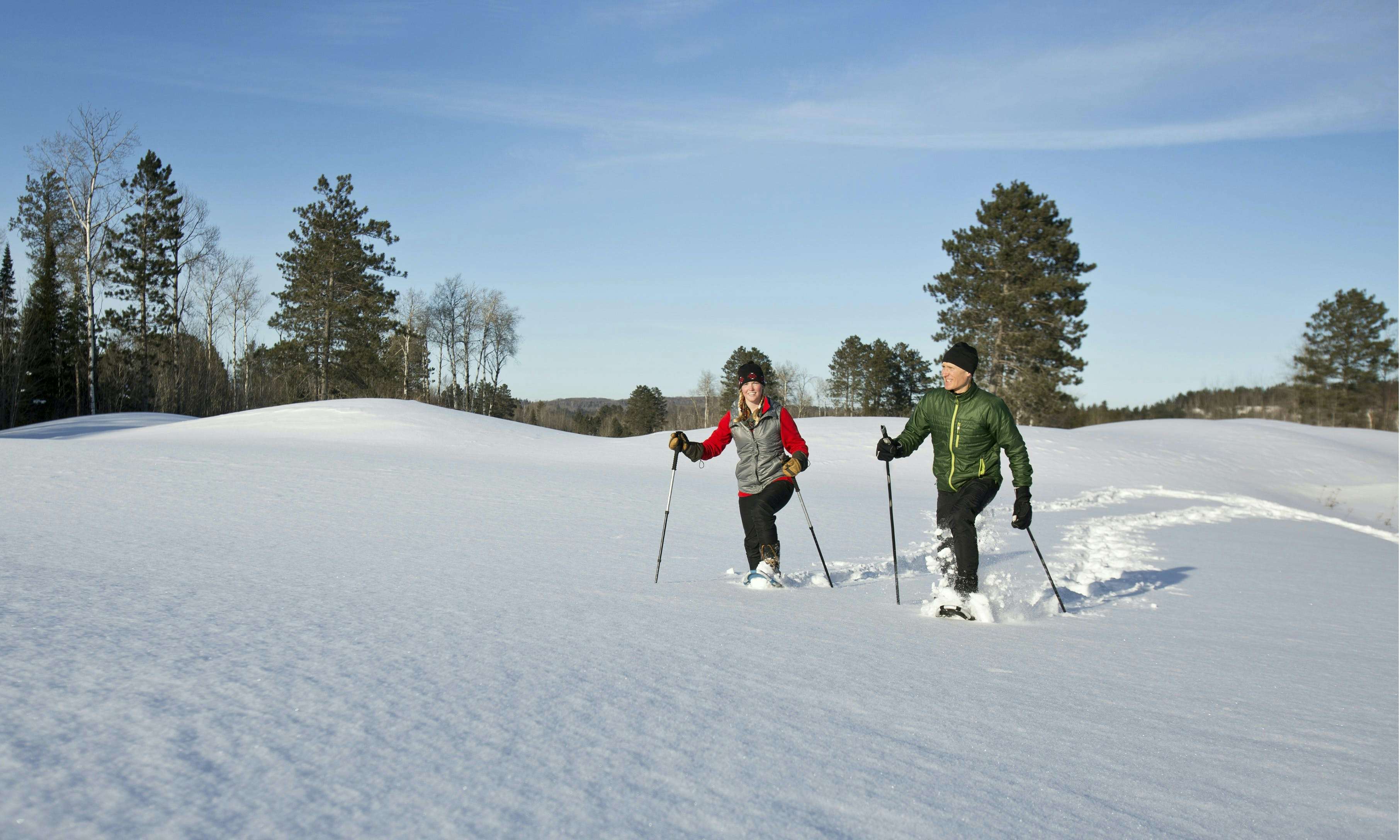 Two people snowshoeing in an open field