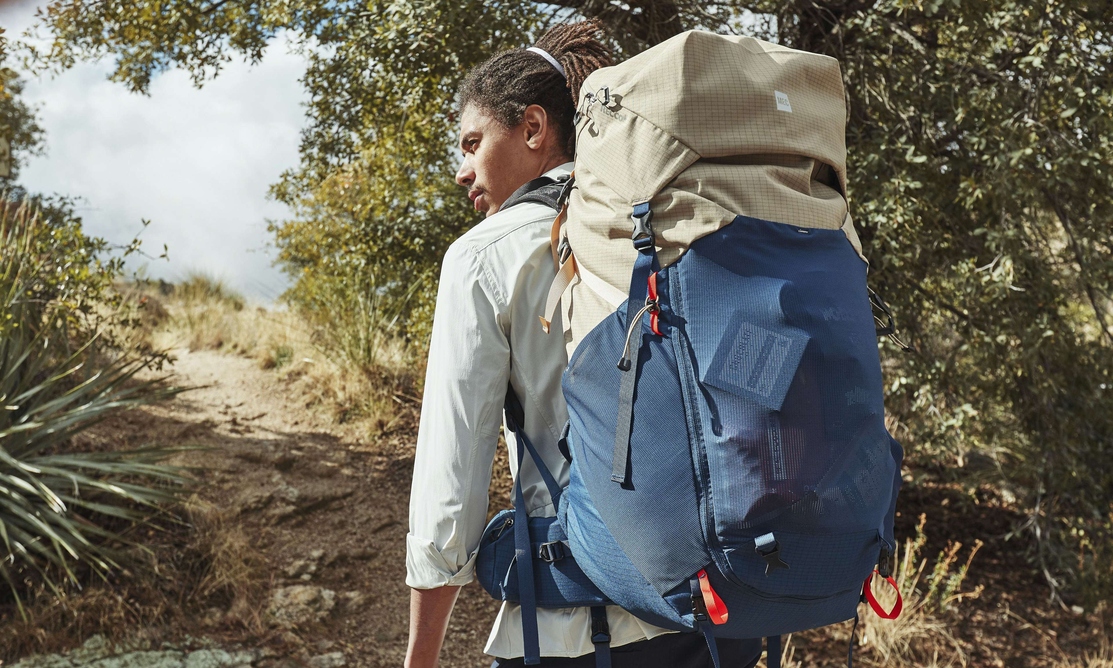 Hiker with large backpack walking on a trail
