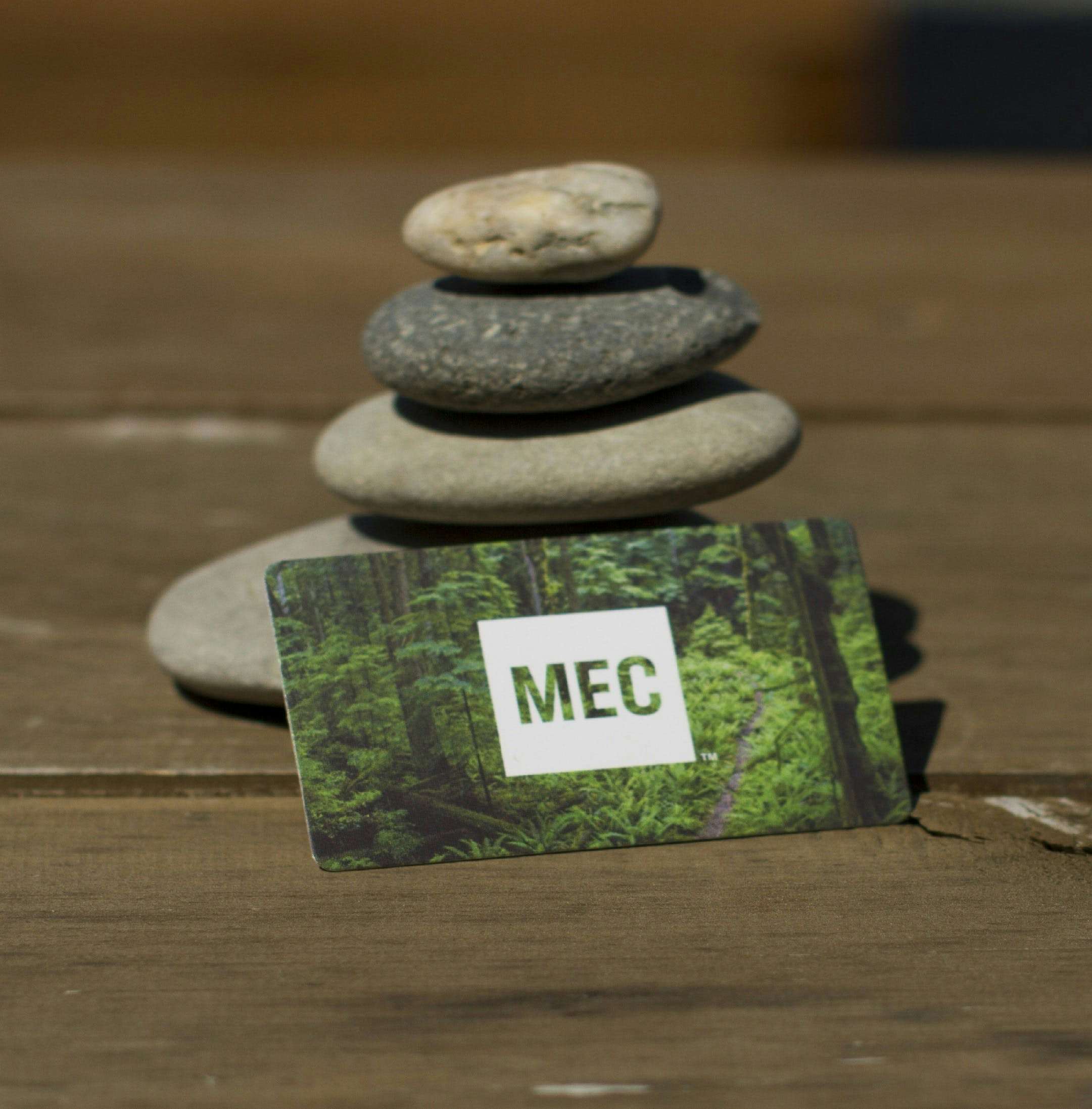 MEC logo on gift card leaning against stones