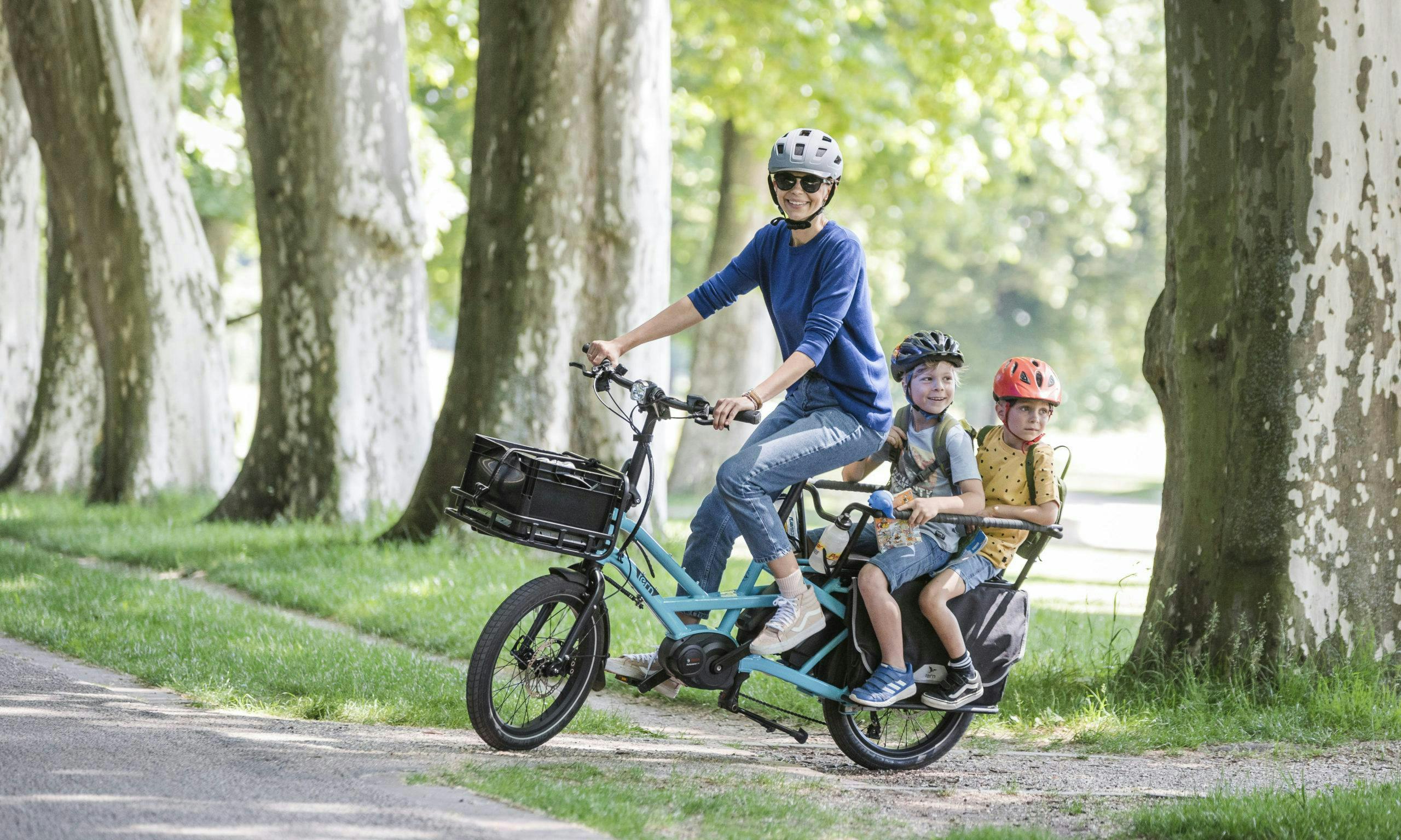 Parent with two kids on a Tern e-cargo bike