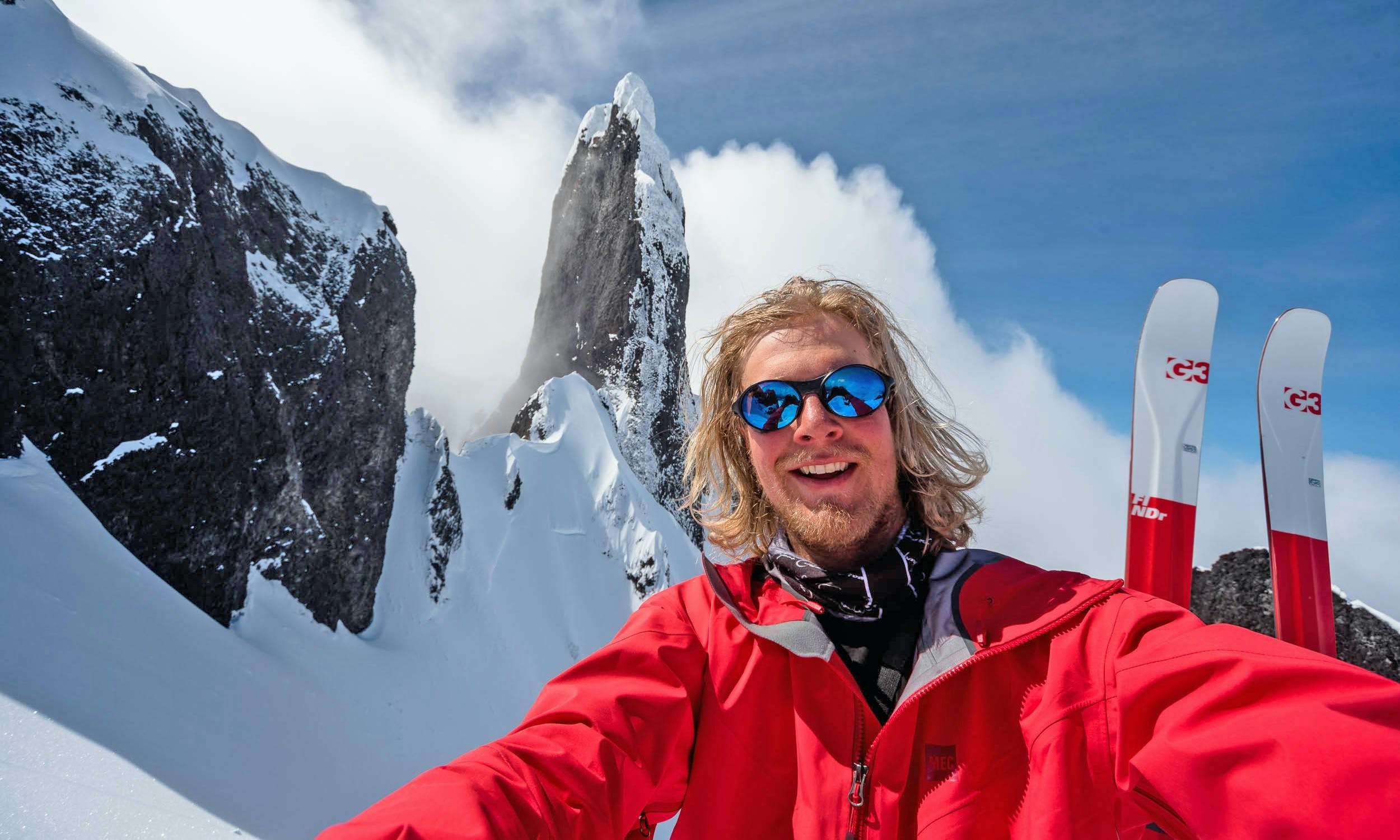 Photographer Reuben Krabbe takes a selfie, surrounded by huge snowy mountains