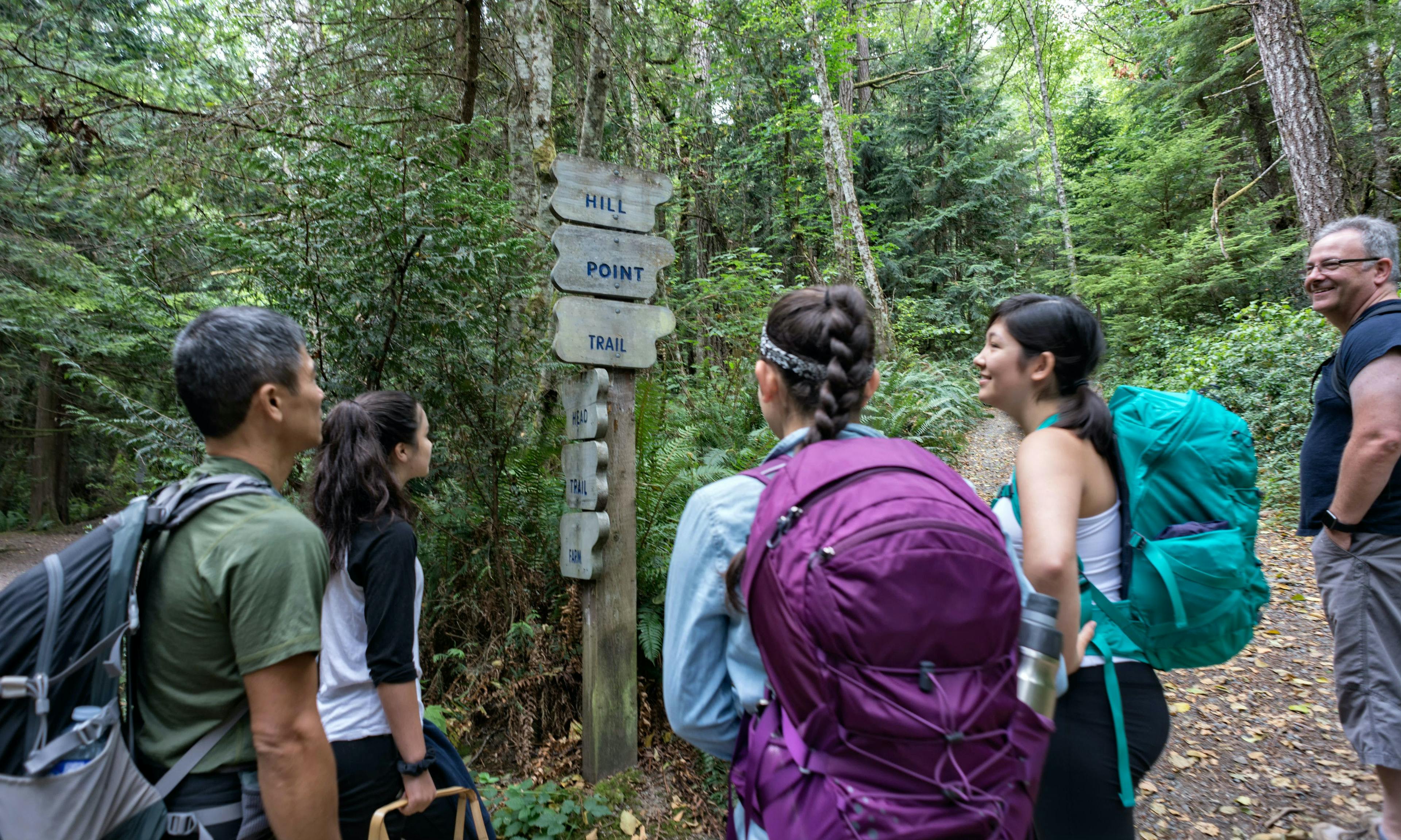 Group of hikers looking at a trail sign