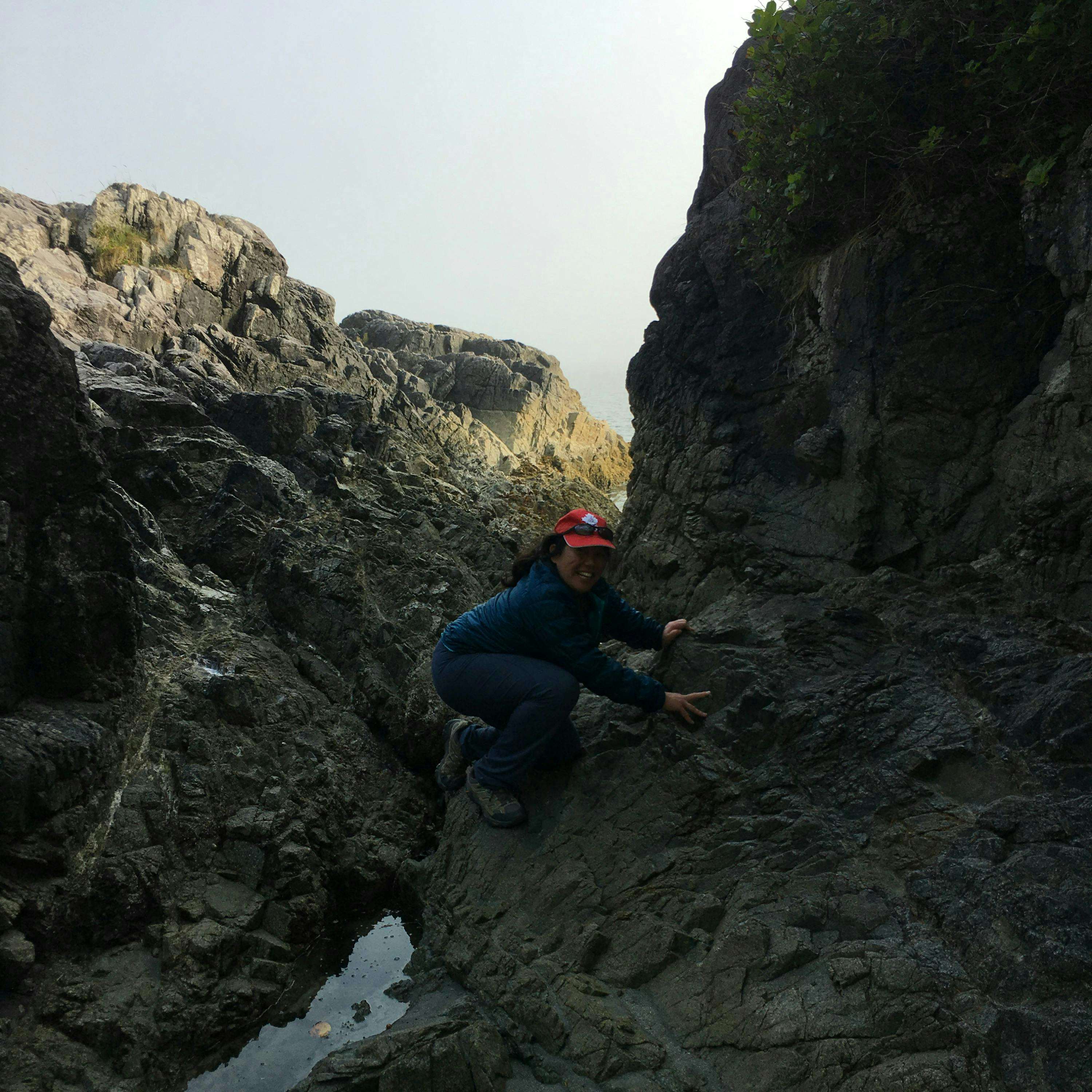 Karen Lai climbing rocks near the shore