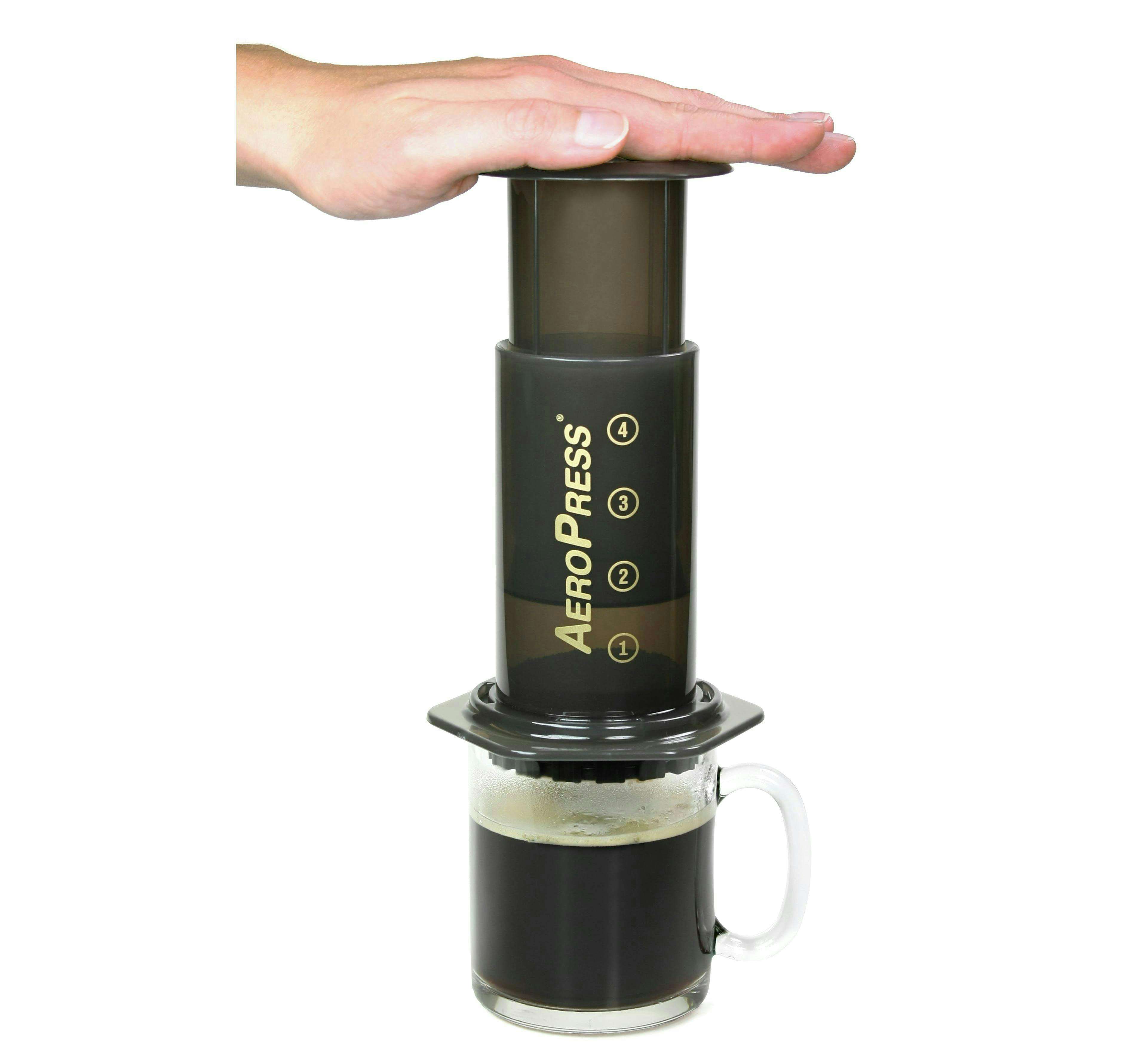 Close-up of a person pressing an Aeropress to make coffee