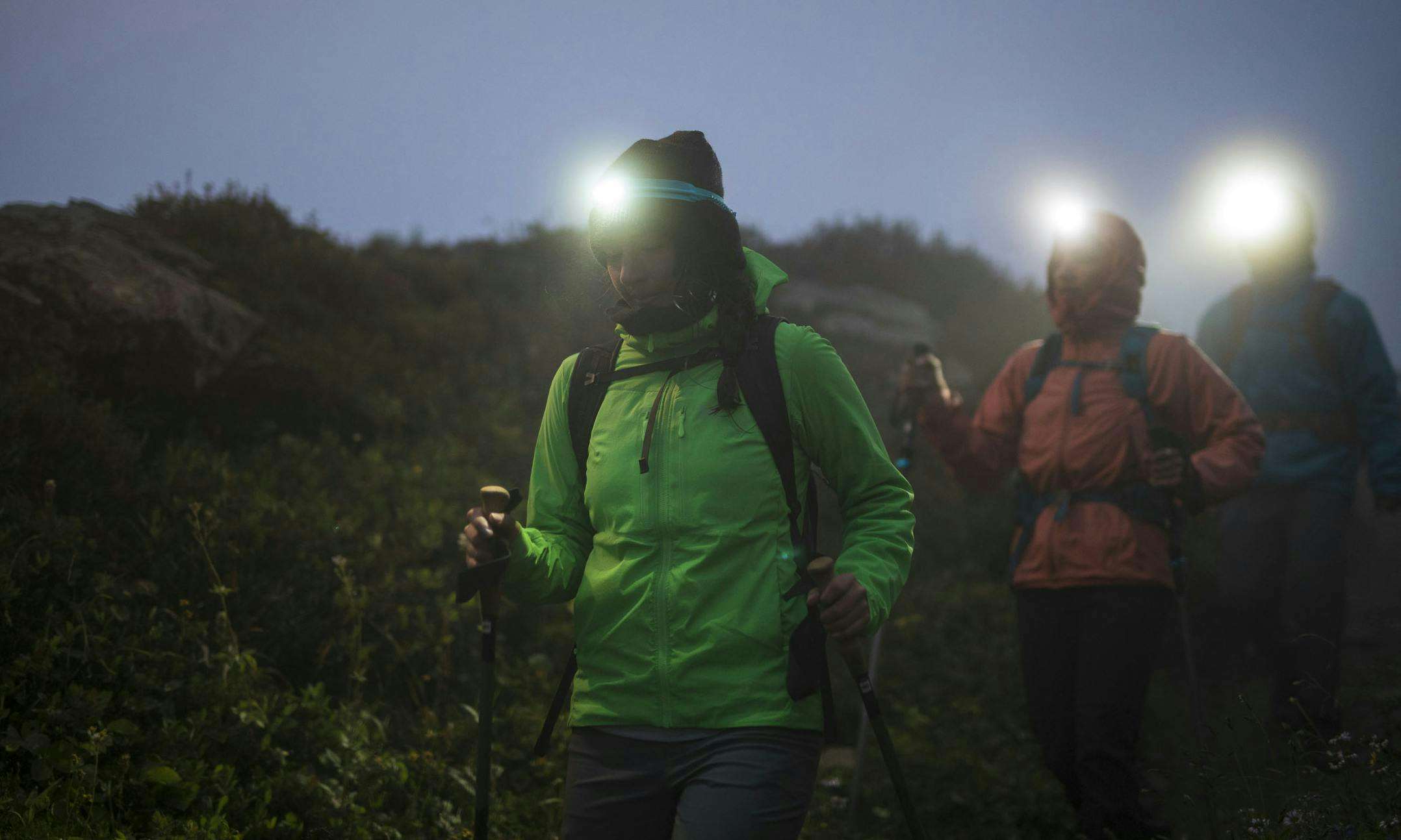 Two hikers wearing headlamps at dusk